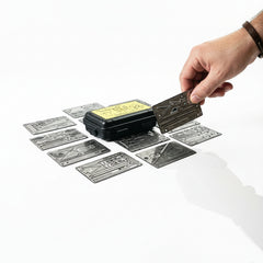 flatlay photograph of the complete survival card bundle stored inside a compact metal tin.
