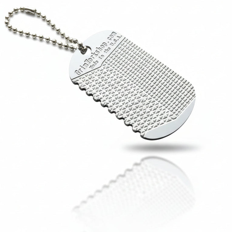 Stainless steel file dog tag shown at dog tag size for scale and everyday carry reference.